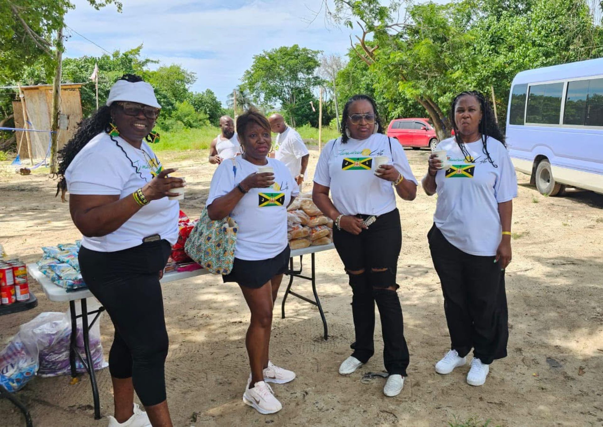 Four women in matching Jamaica-themed shirts.
