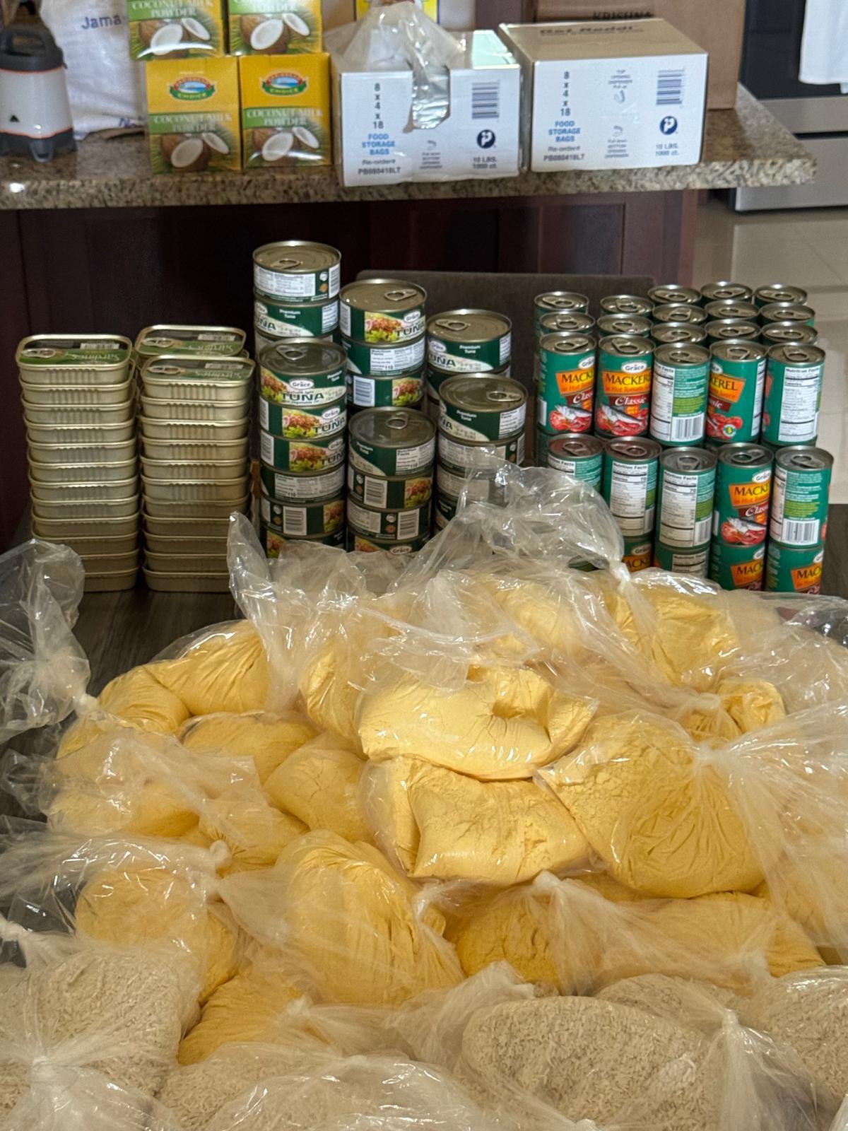 Canned goods and packaged noodles on table.