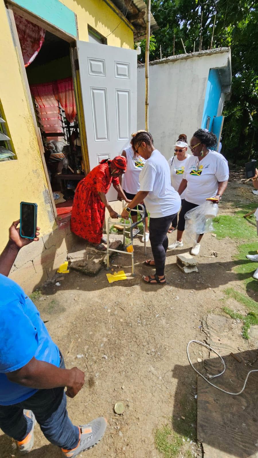 Group assisting woman entering a building.