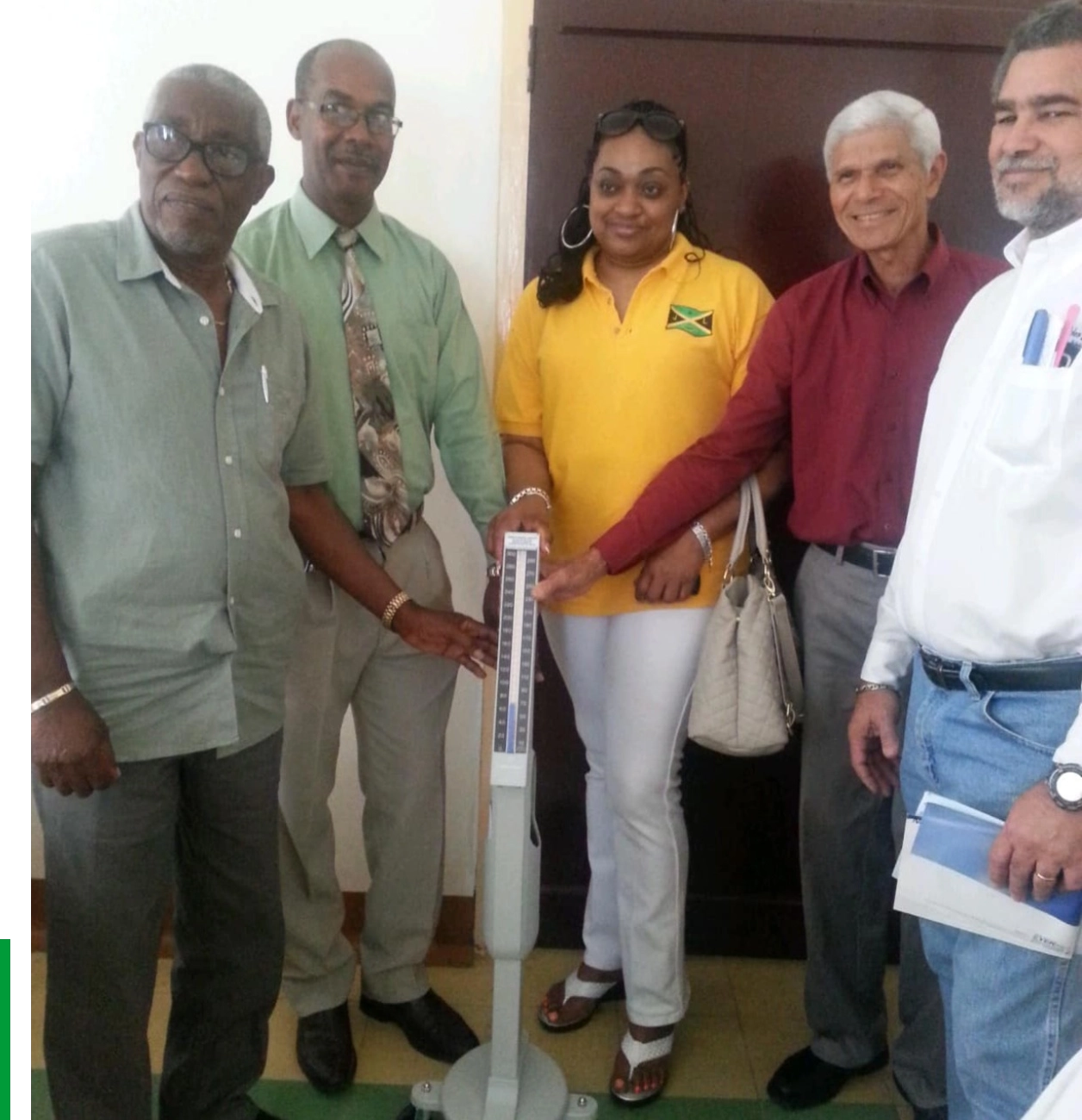 Group standing around a medical scale smiling.