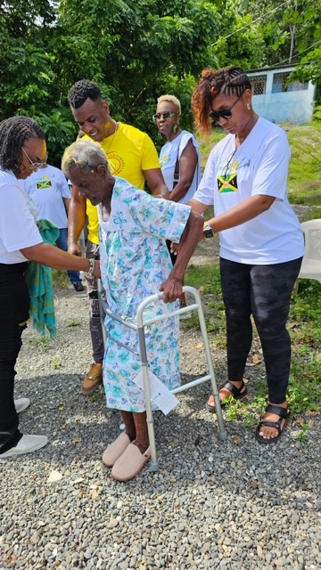 Elderly woman using a walker with assistance.