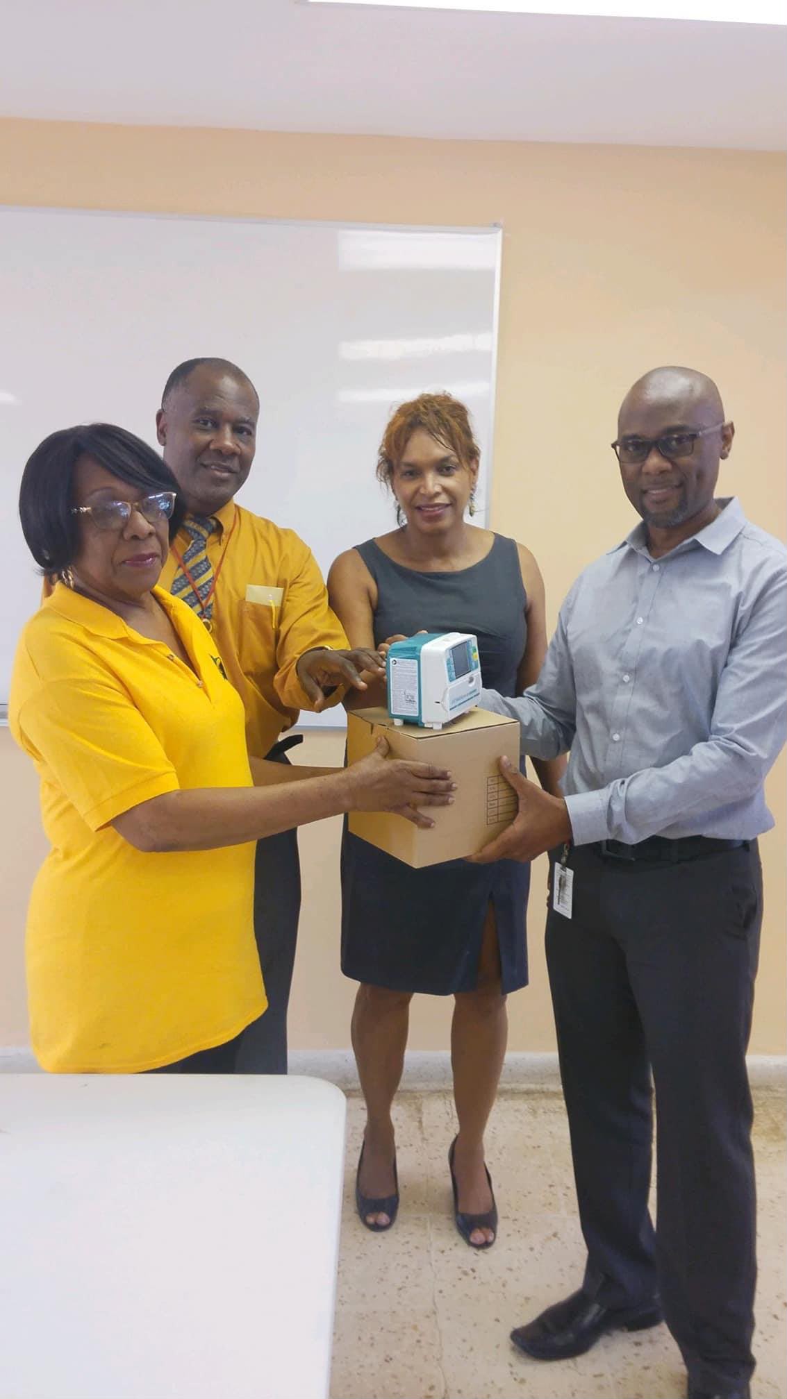 Group presenting medical equipment donation box