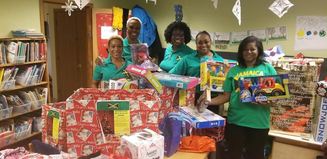 Volunteers posing with wrapped gifts in library
