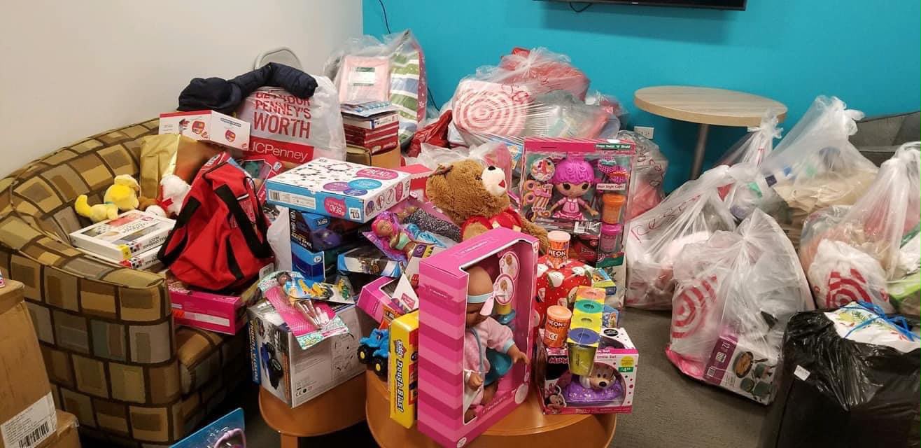 Donated children's toys piled with shopping bags