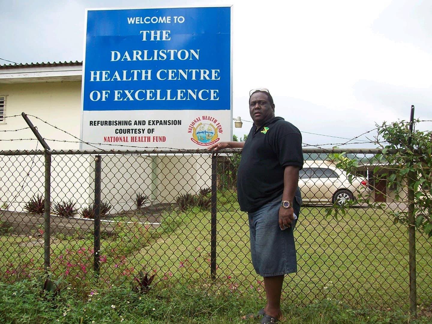 Man standing beside Darliston Health Centre sign
